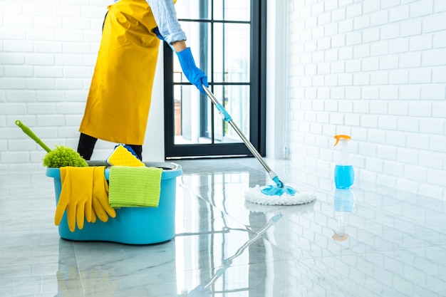 happy-young-woman-blue-rubber-using-mop-while-cleaning-floor-home_28283-1482